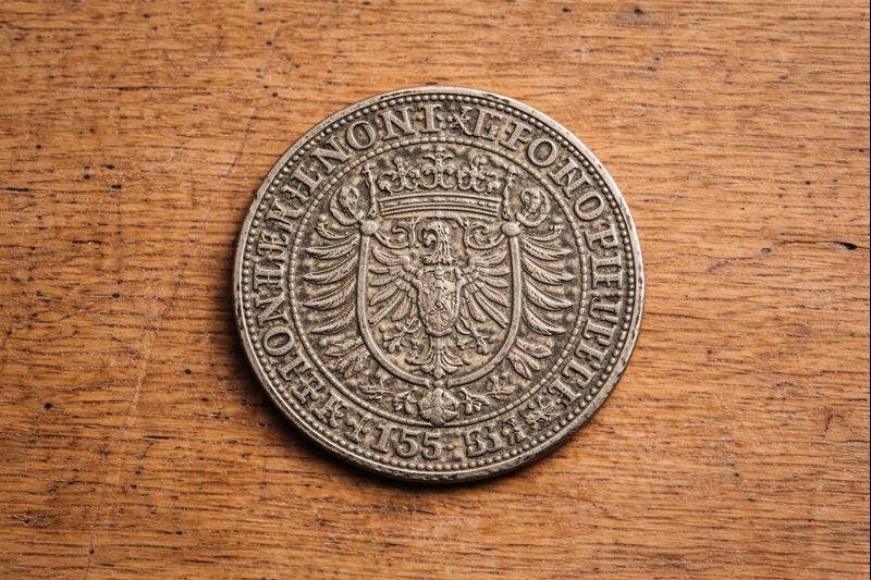 Large Silver-Colored Coin with Royal Motifs