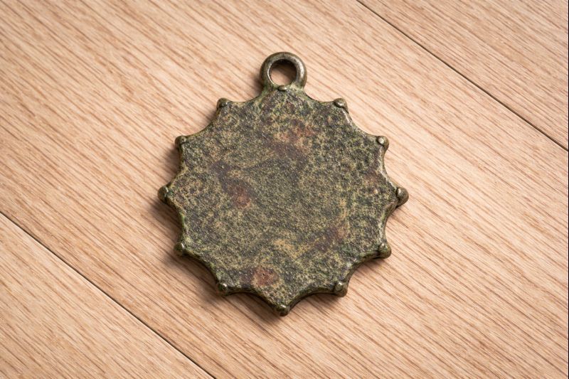 Bronze Sunburst Amulet with Central Stone